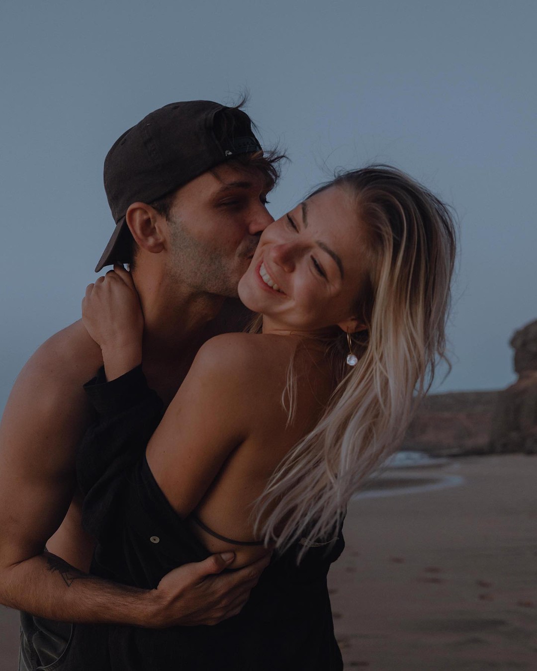 moški poljublja žensko na lice